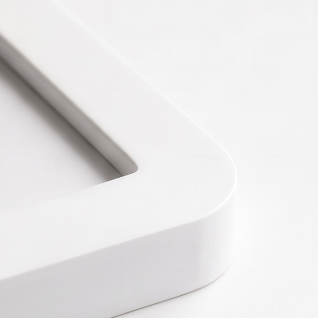 Close-up of a white rectangular object with rounded edges on a light gray background