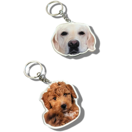 Two keychains with dog faces on a white background